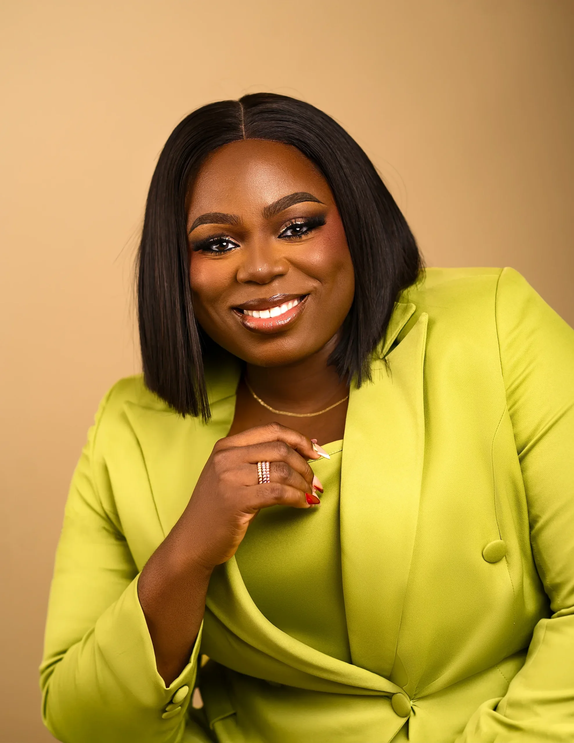 Joy Bukar smiling, in a lime tailored suit